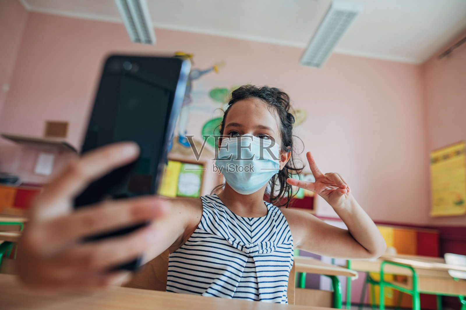 女学生戴着防护面罩在教室里自拍照片摄影图片