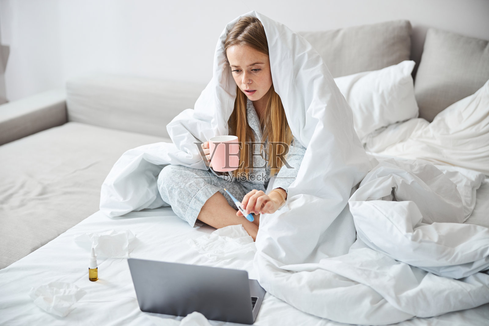 生病的年轻女子用数字温度计在线与医生交谈照片摄影图片