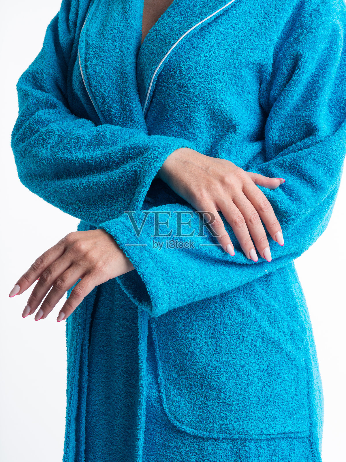 在一个孤立的白色背景上，穿着明亮晨衣的女人在做服装细节的广告。照片摄影图片