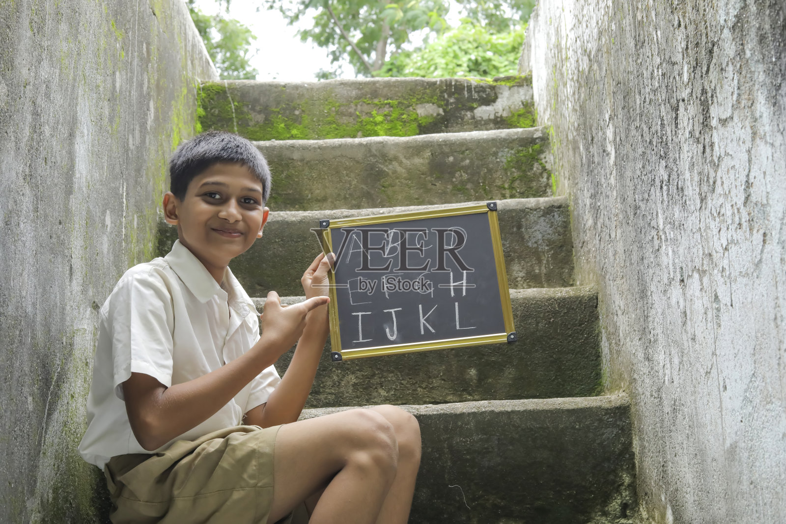 印度小孩在黑板上写字母照片摄影图片