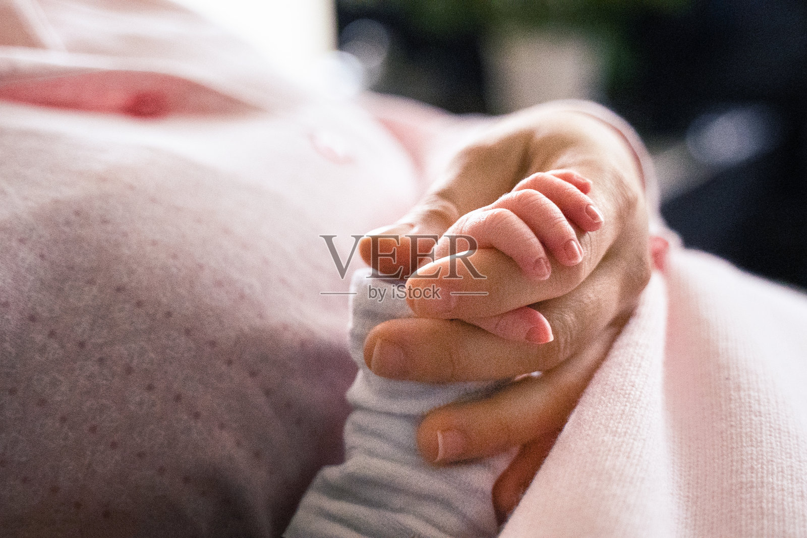 COVID-19大流行期间的新生儿。小女孩握着她妈妈的手指。照片摄影图片