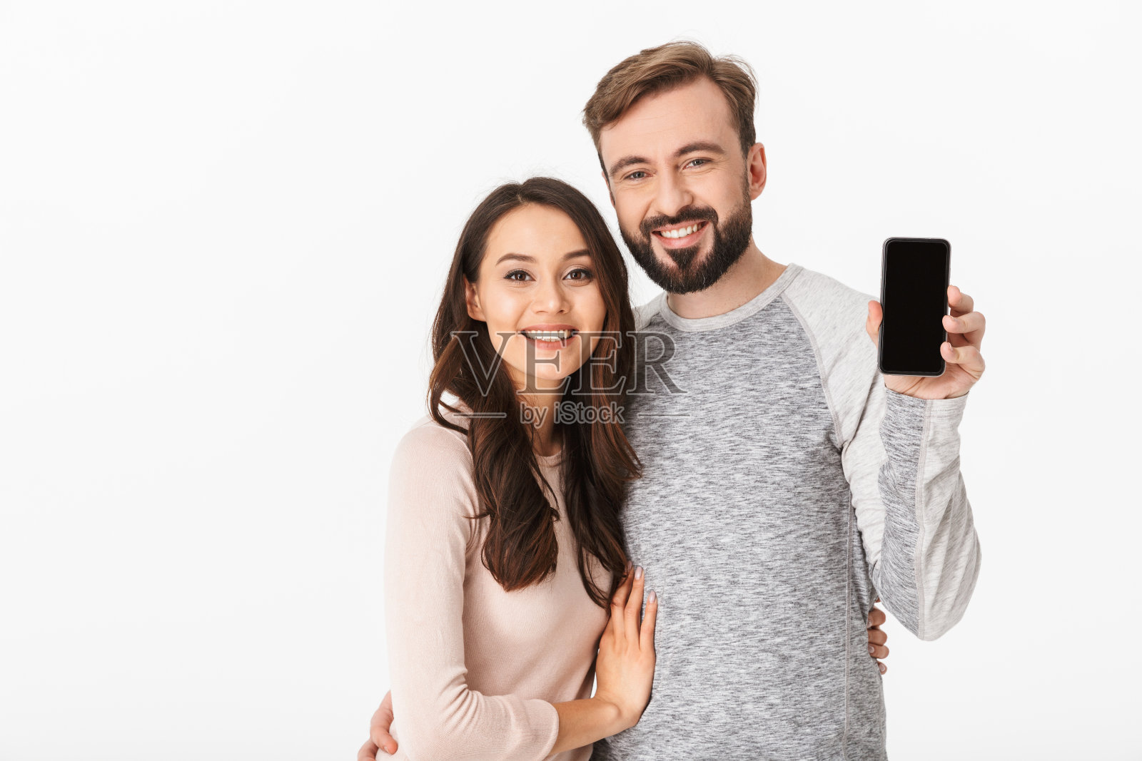 幸福的年轻情侣展示的手机。照片摄影图片