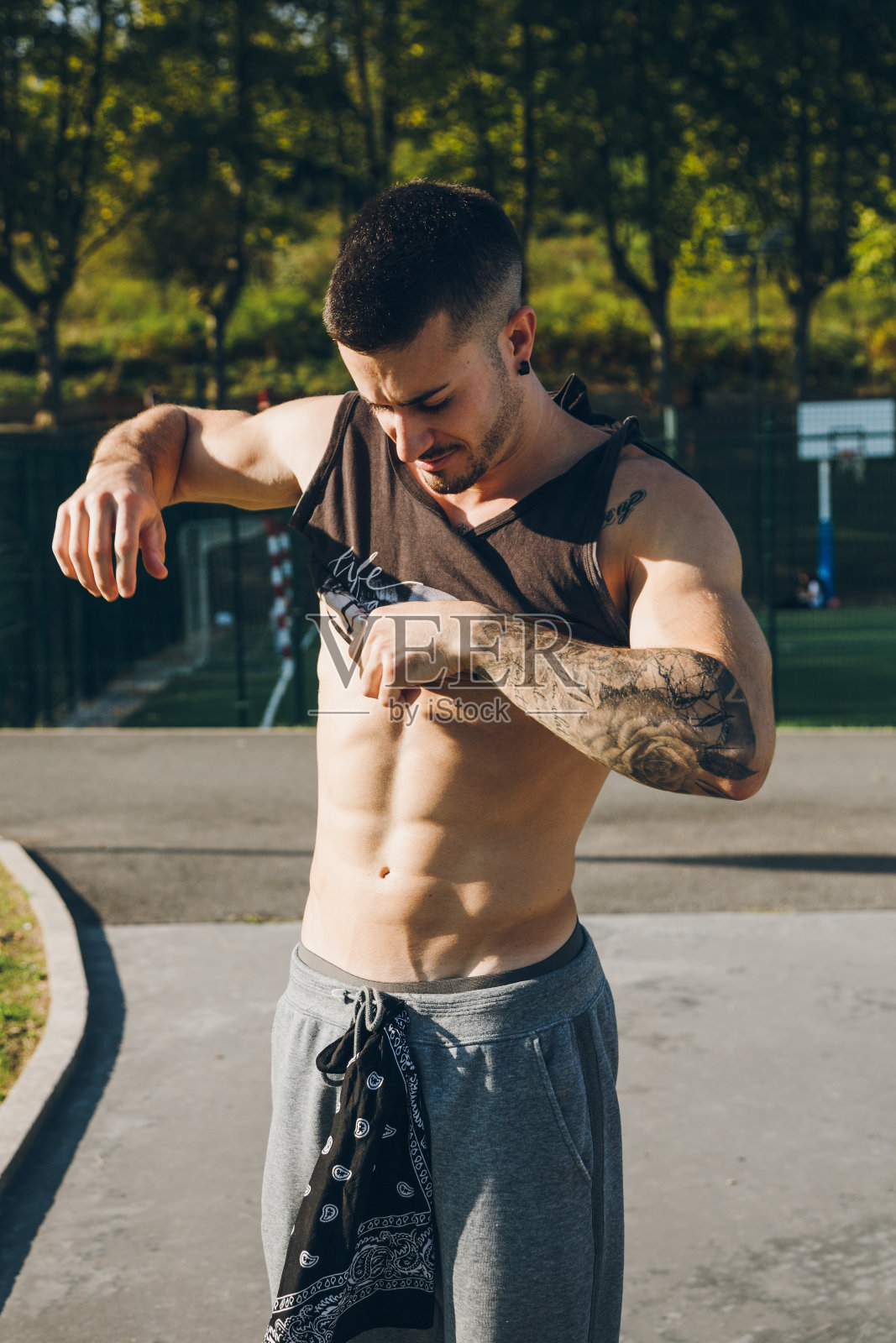 年轻的城市健美运动员在进行健美操训练前脱下衬衫照片摄影图片