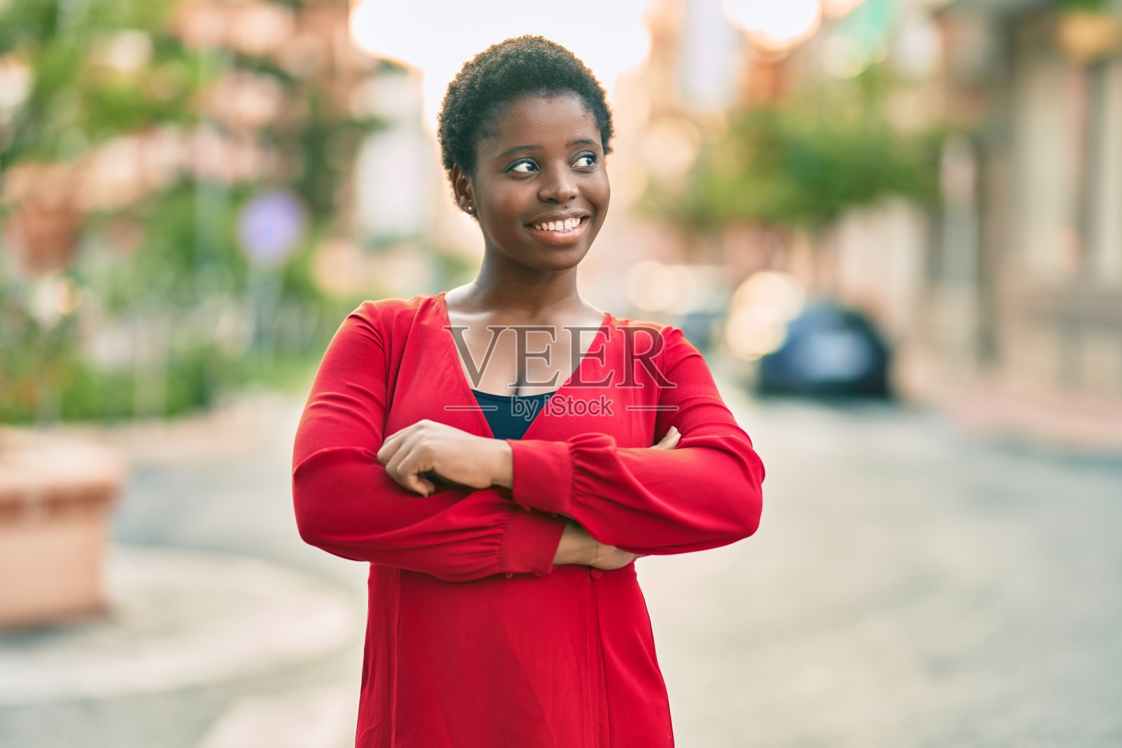 年轻的非裔美国妇女微笑快乐地站在城市。照片摄影图片