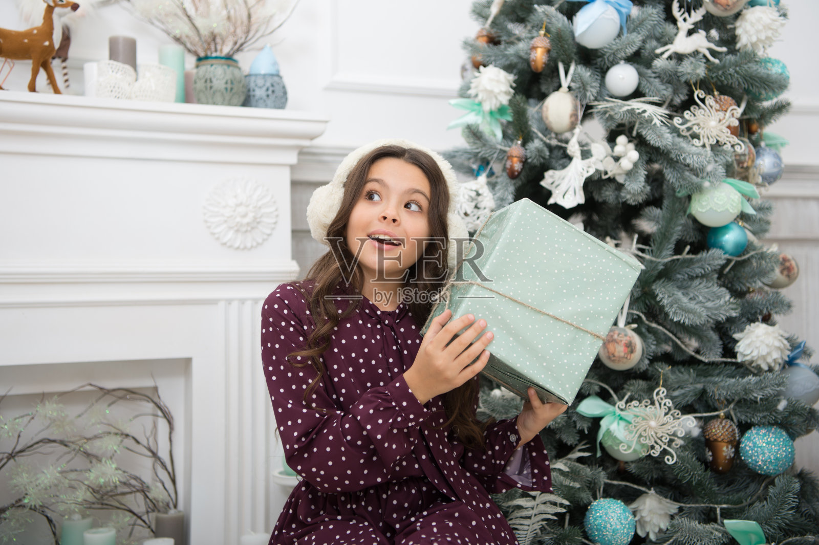 小女孩喜欢圣诞礼物。圣诞节前的早晨。新年假期。圣诞节。孩子们享受假期。新年快乐。圣诞节快乐的小女孩。购物中心。圣诞节是在这里照片摄影图片