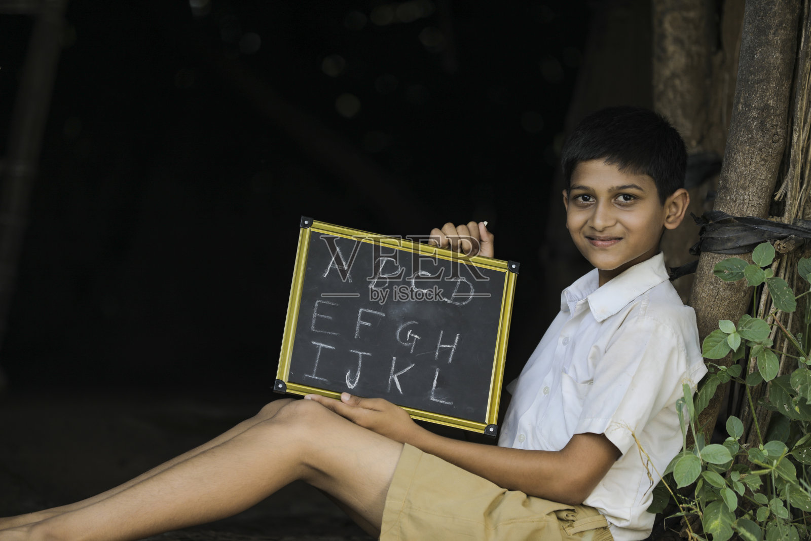 印度小孩在黑板上写字母照片摄影图片