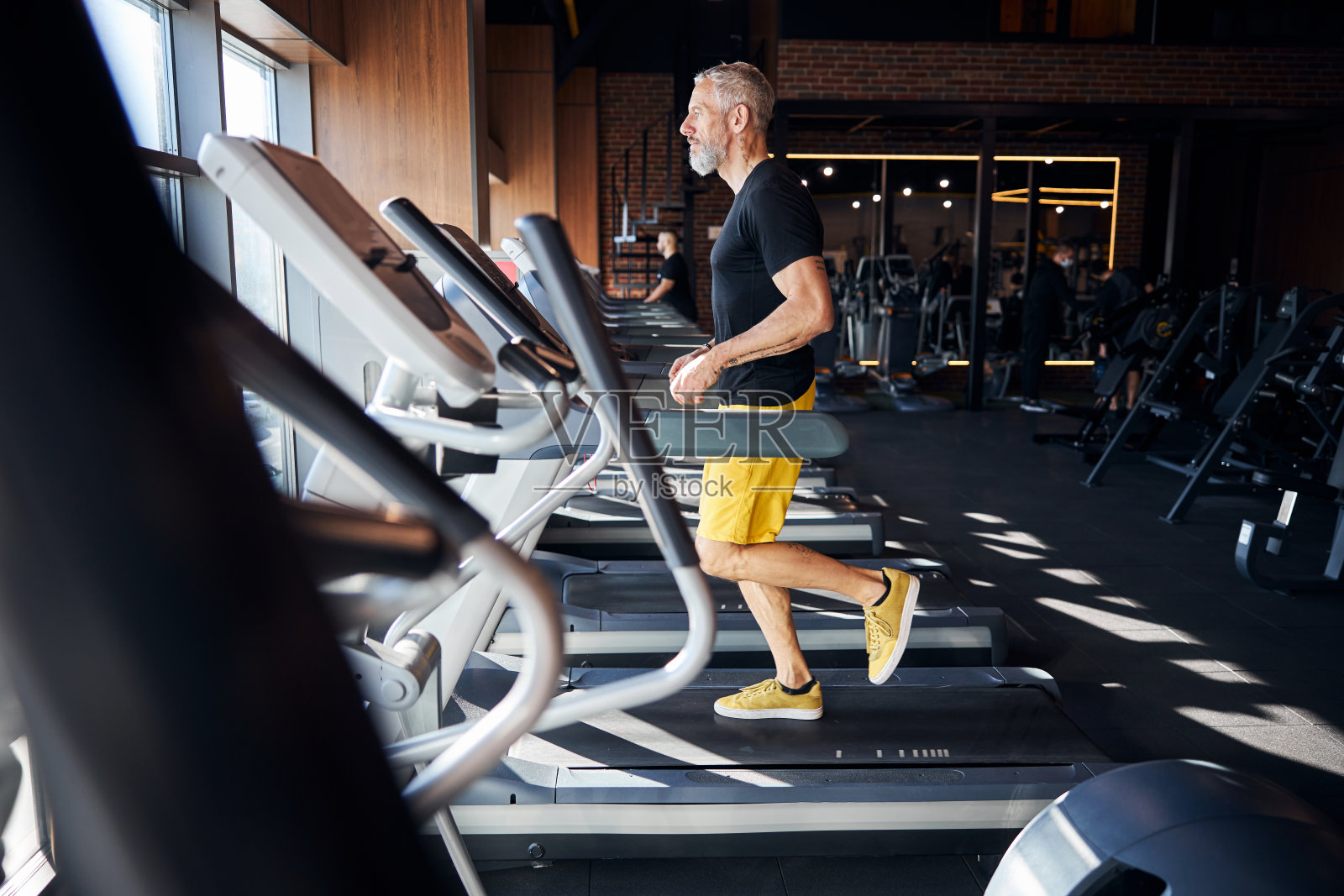 专注的运动员在有氧运动机上锻炼照片摄影图片