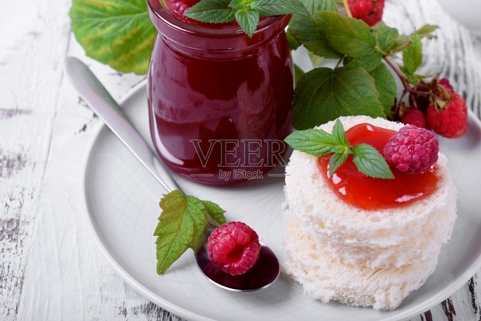 涂上覆盆子酱的白小麦面包片照片摄影图片