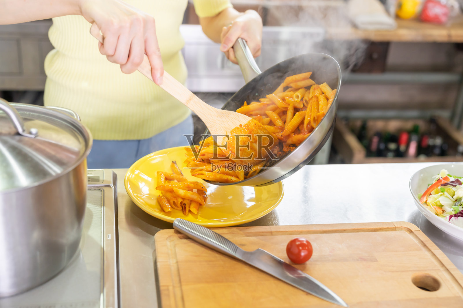 亚洲女人在厨房里做饭，意大利面，手照片摄影图片