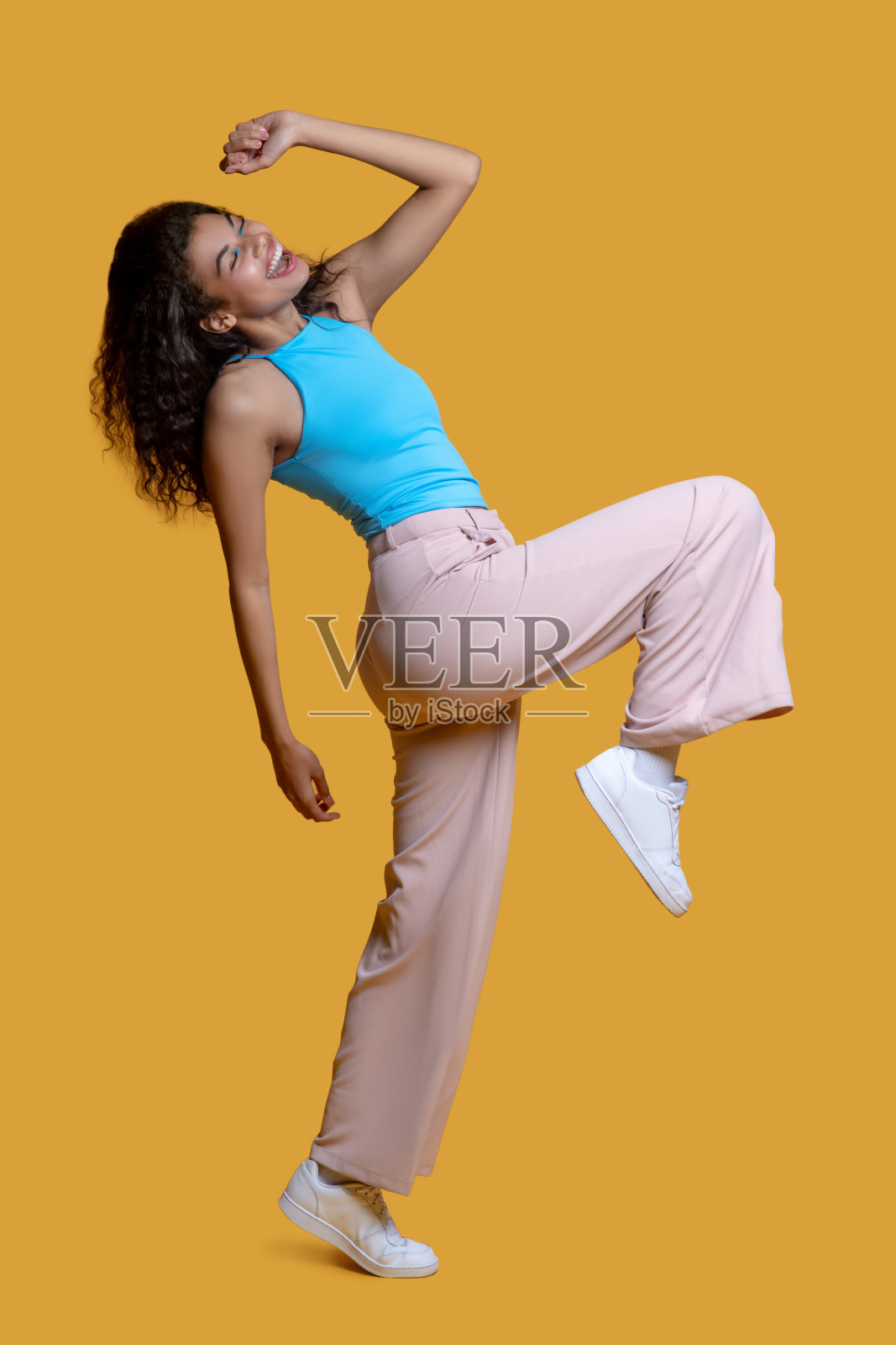 年轻的黑头发女人穿着蓝色的上衣感到高兴照片摄影图片