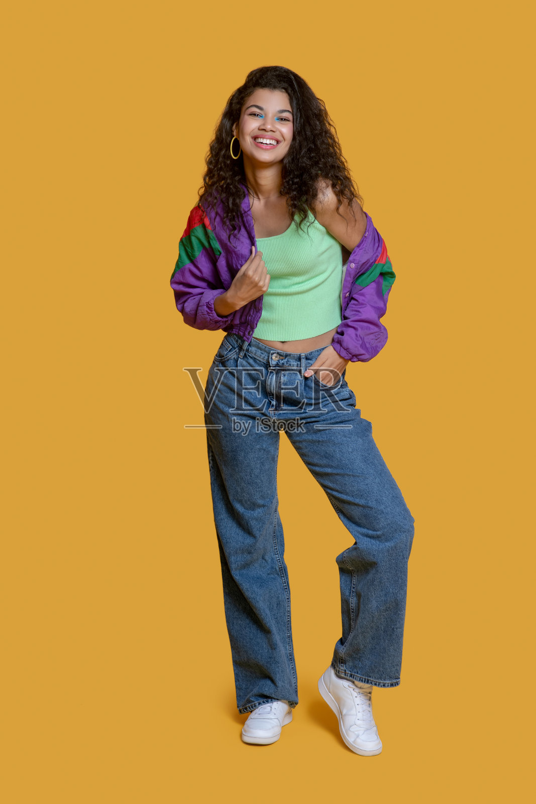 漂亮的黑发年轻女孩穿着鲜艳的夹克摆姿势照片摄影图片