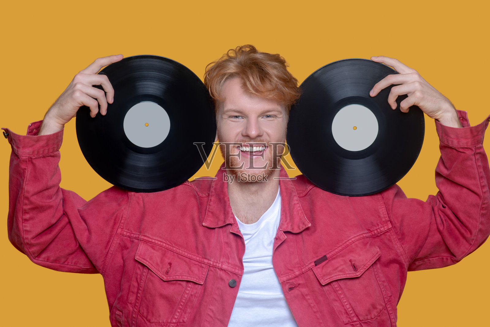 红发大胡子年轻人，穿着红夹克，微笑着记录照片摄影图片