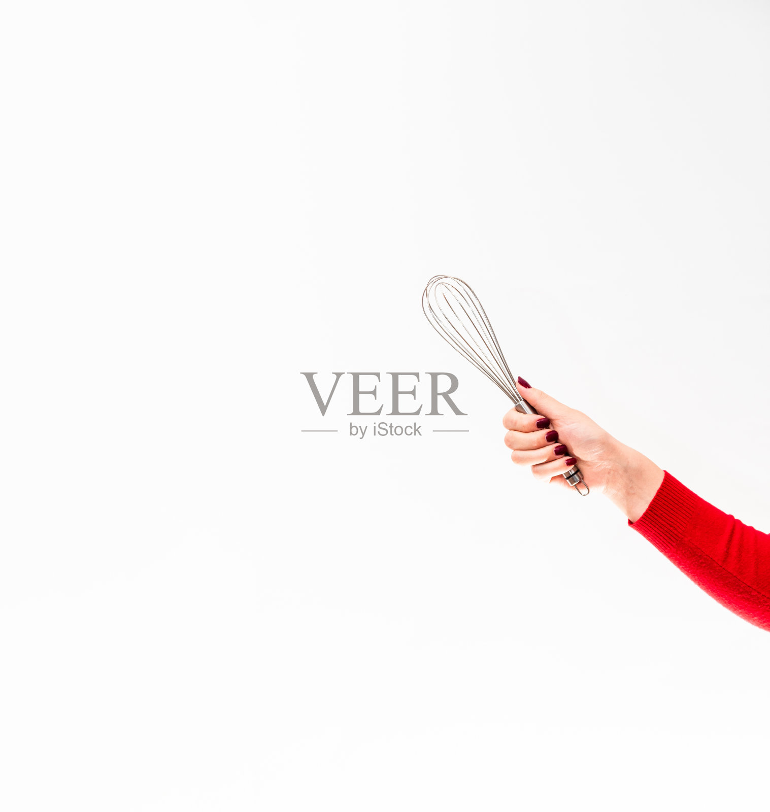 打蛋器用来在白色背景上用女性的手做甜点。文本空格。照片摄影图片