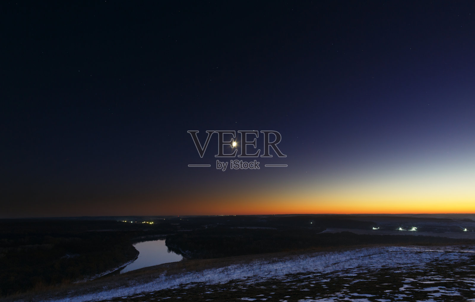 黄昏时河上的新月。日落后明亮的夜空。照片摄影图片