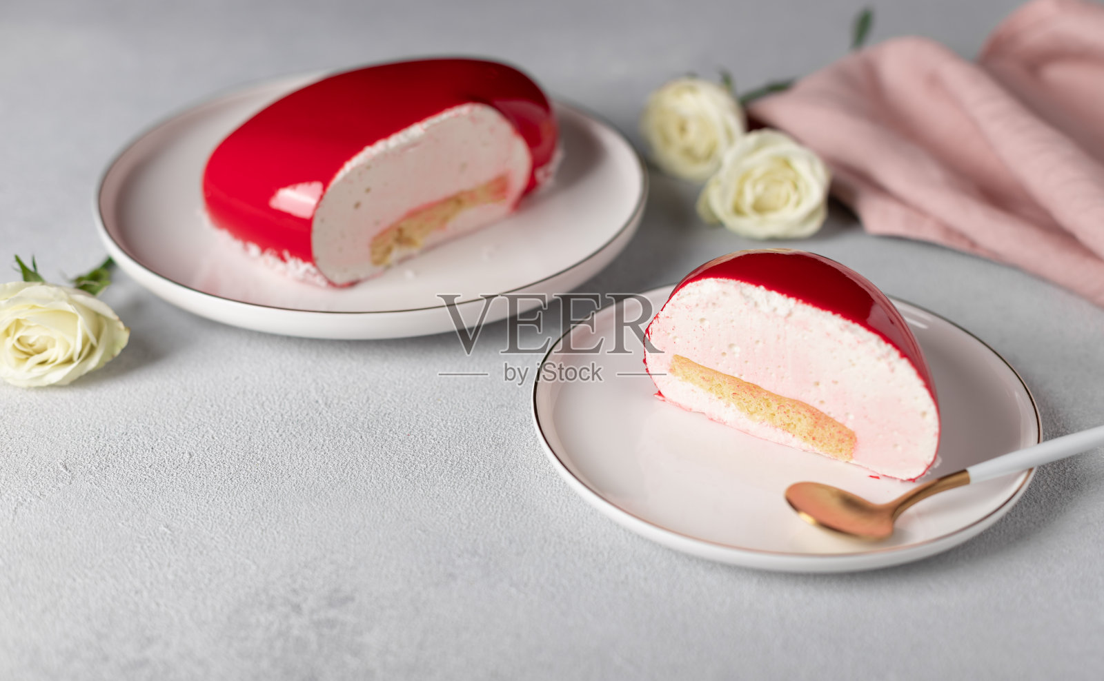 白色盘子上的慕斯蛋糕，灰色背景，白色玫瑰照片摄影图片