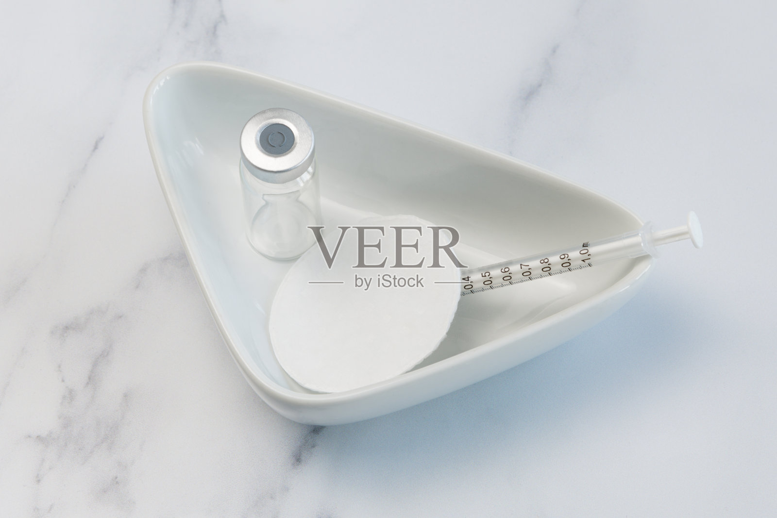 1支医用疫苗安瓿和1支注射器，注射器内装有清洁棉拭子，置于医用盘内。照片摄影图片