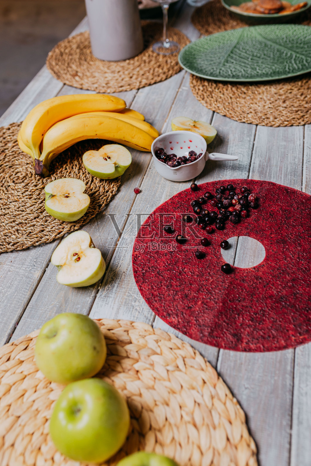 黑醋栗果皮和新鲜水果放在木桌上。圆形红色水果皮革与黑醋栗。健康食品。苹果，香蕉俯视图。照片摄影图片