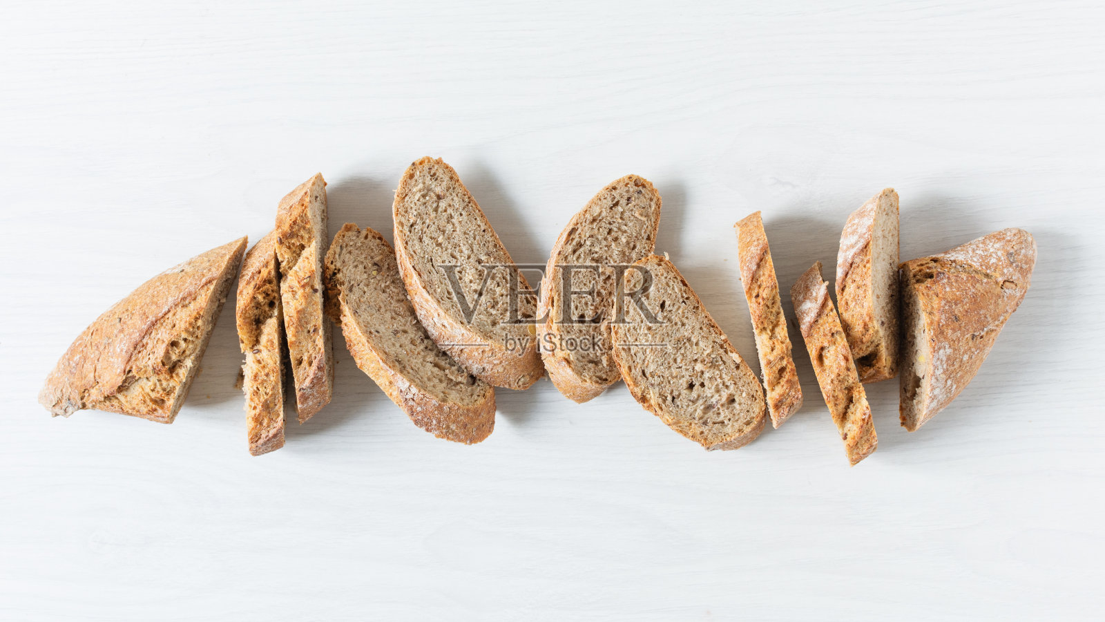 面包切在白色木制桌子上的顶部视图。照片摄影图片