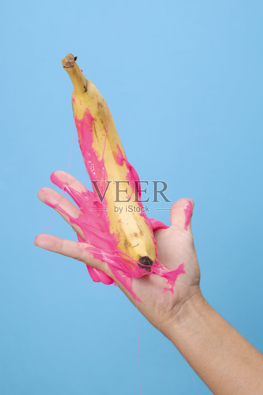 手握有机香蕉切片在蓝色的纸背景。照片摄影图片