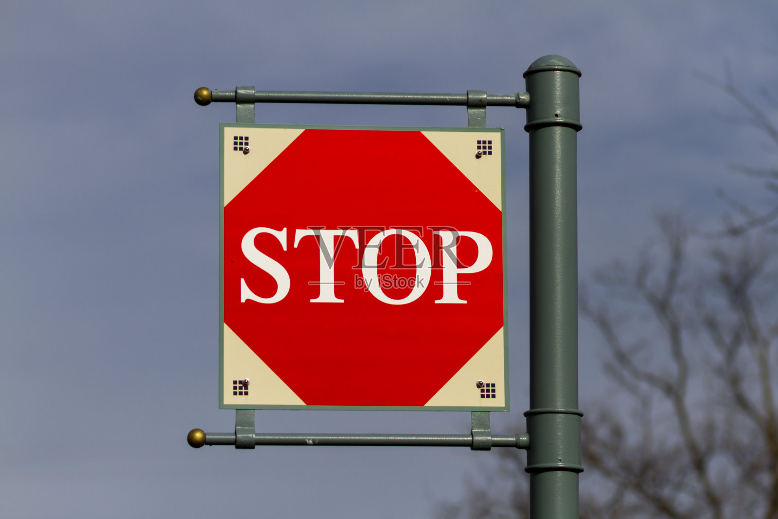 孤立的方形“停止”标志通过铰链固定在一个金属路标上，悬挂在空中。照片摄影图片