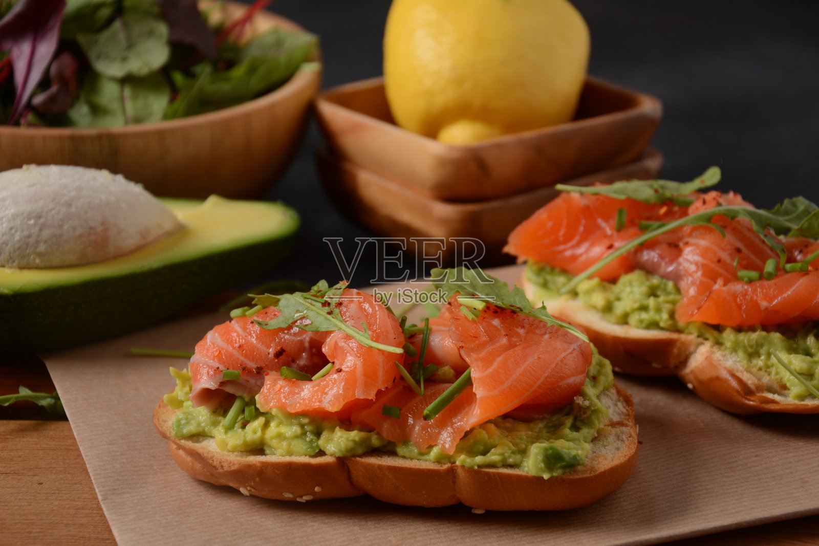 含有牛油果酱和三文鱼的全麦面包，芝麻菜叶。照片摄影图片
