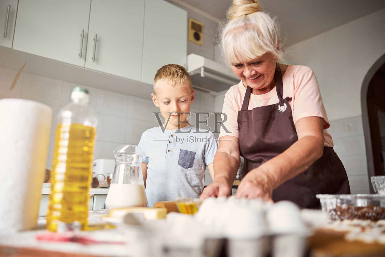一位和蔼的老妇人和她的孙子一起做饭照片摄影图片