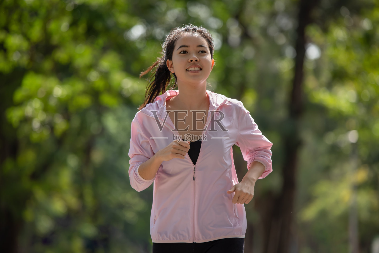 年轻的亚洲女运动员在公园里跑步照片摄影图片