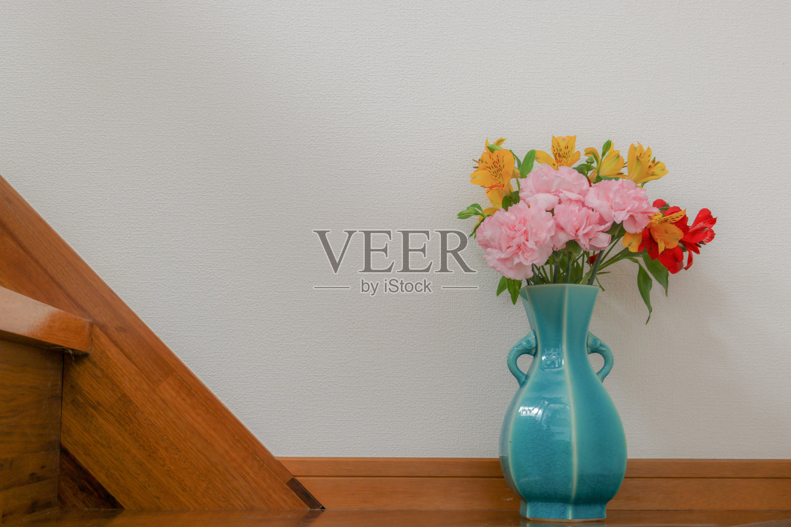 蓝色花瓶里有一束紫花和康乃馨照片摄影图片