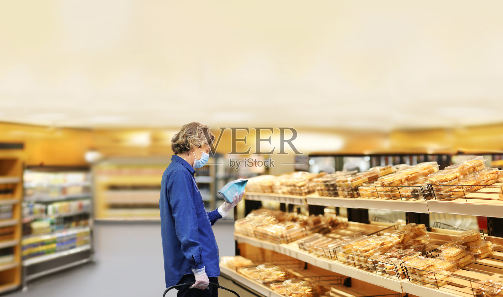 超市购物，口罩和手套，年轻人在超市购物，阅读产品信息照片摄影图片