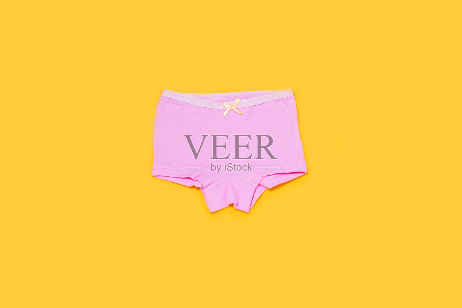 黄色背景的小女孩内衣。照片摄影图片