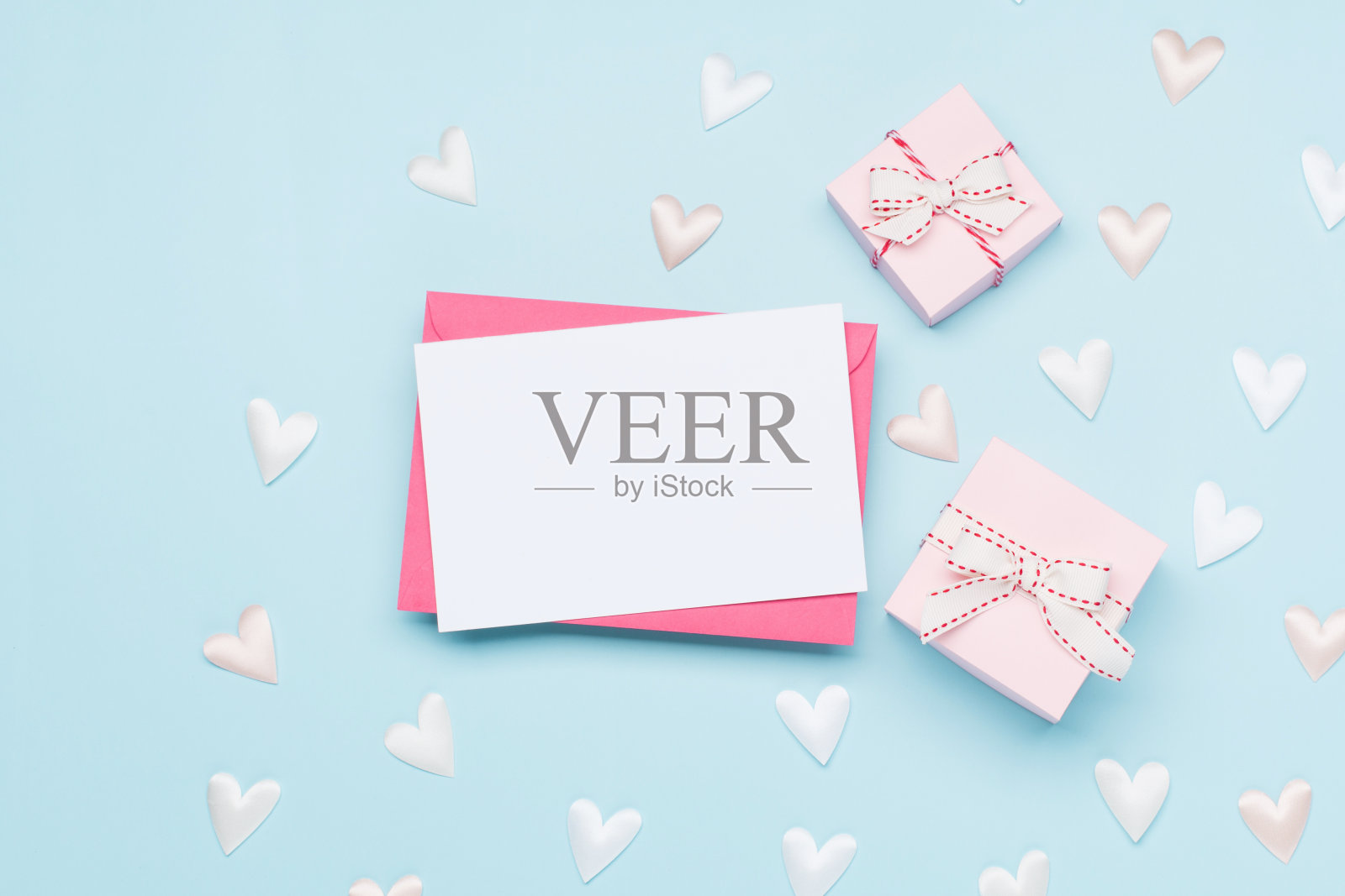 粉白色的心形纺织品和空信封在淡蓝色的背景。情人节的概念。平铺，俯视图，拷贝空间。照片摄影图片