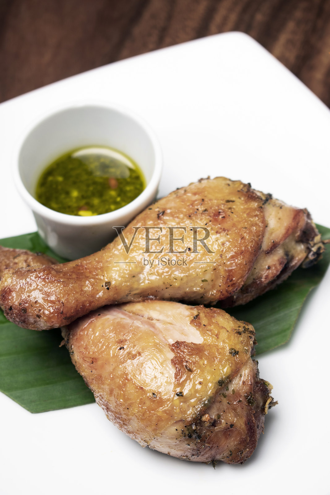 烤鸡腿配香辣泰式绿辣椒酱，配以开胃菜照片摄影图片