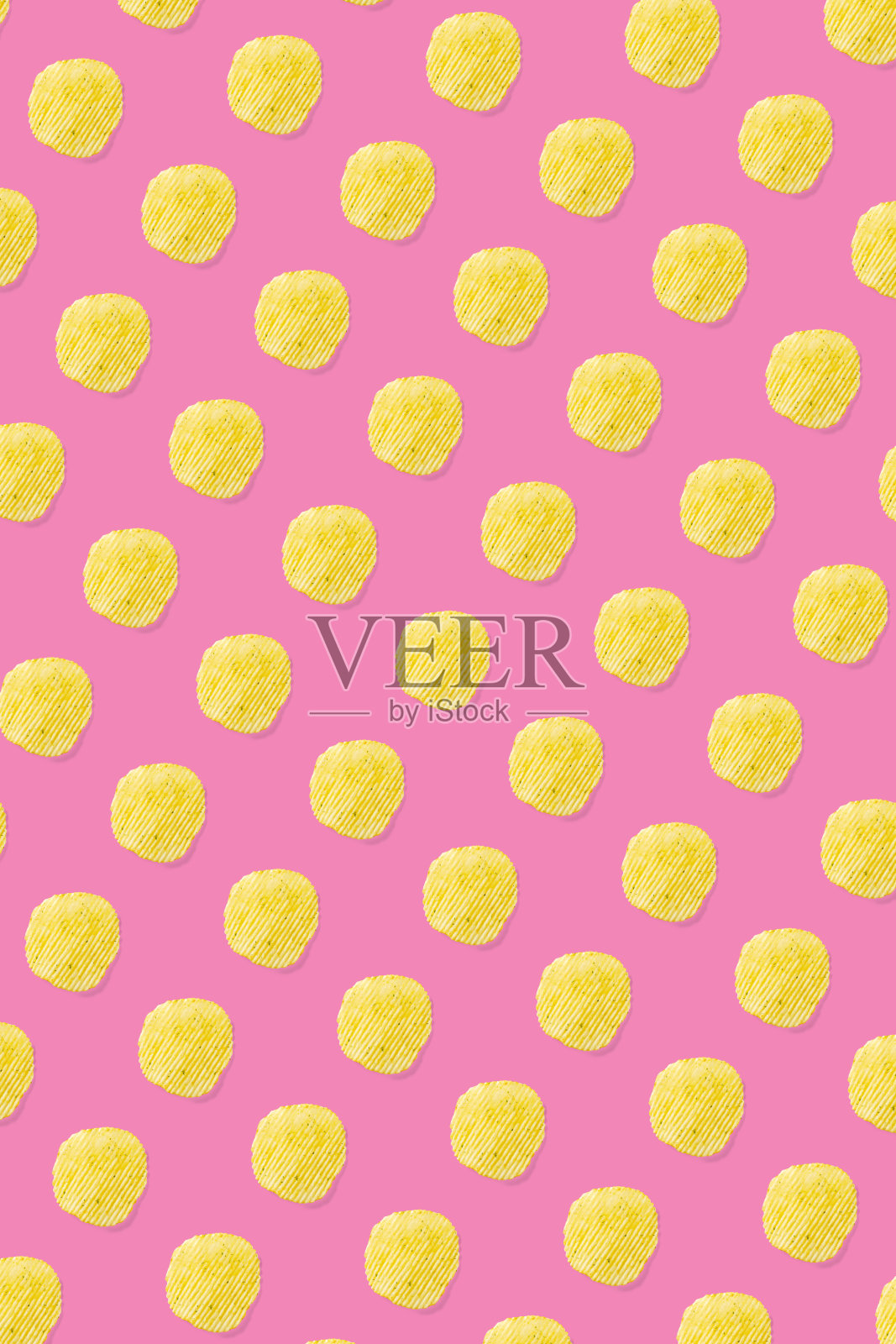 背景由薯片在粉红色的背景上平铺而成。马铃薯零食薯条孤立的快餐横幅。照片摄影图片