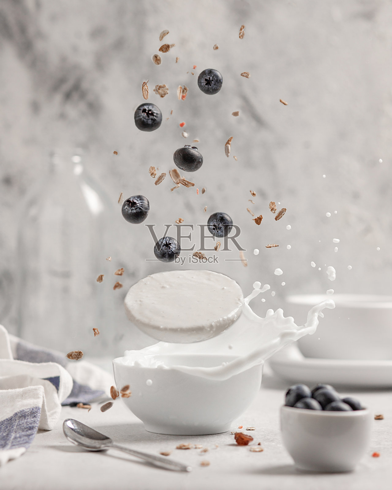 酸奶与蓝莓和什锦麦片在一个较轻的背景。飞行产品的概念，悬浮。照片摄影图片