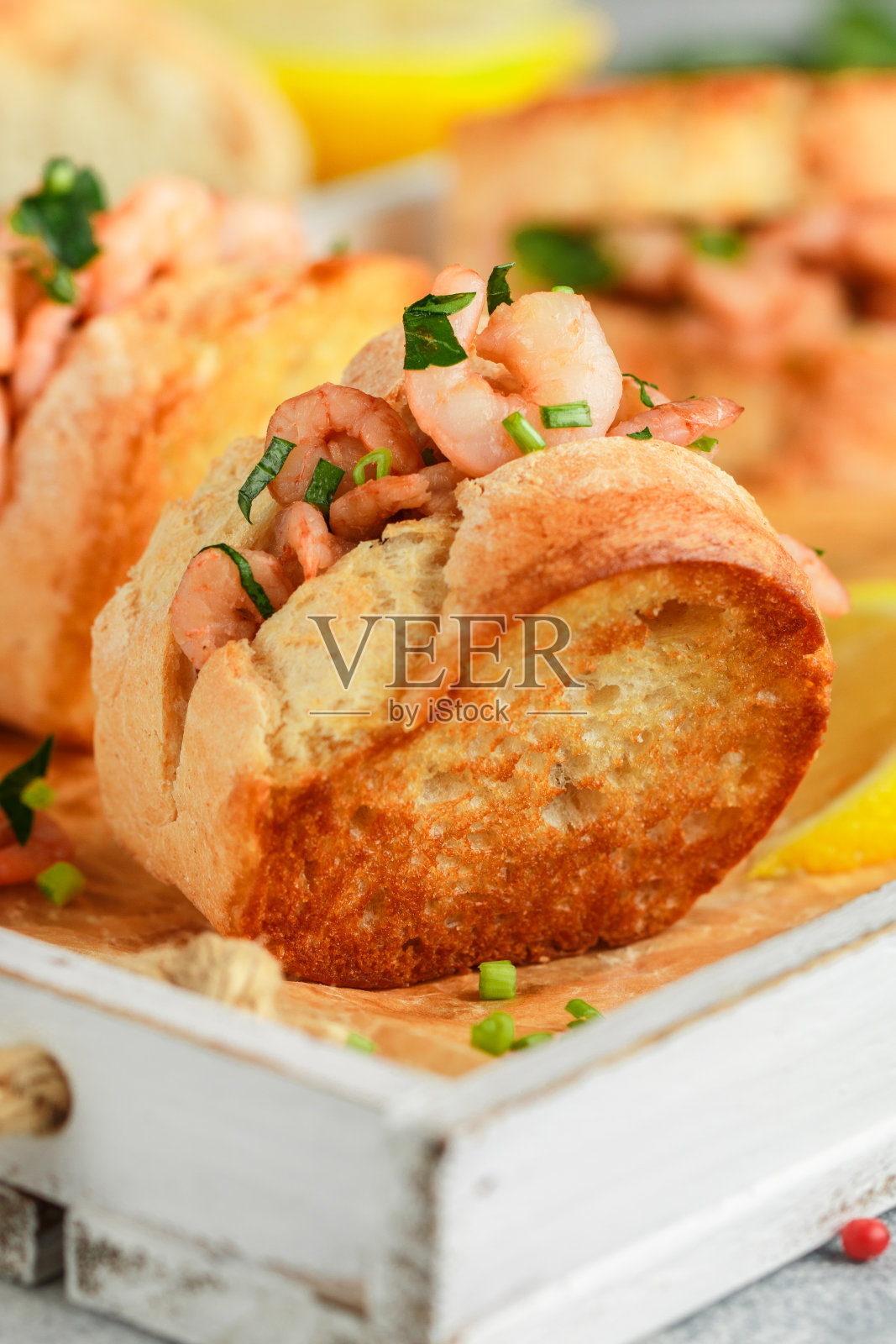 美味的虾和欧芹三明治，配柠檬和香料。温暖的海鲜卷。有选择性的重点照片摄影图片