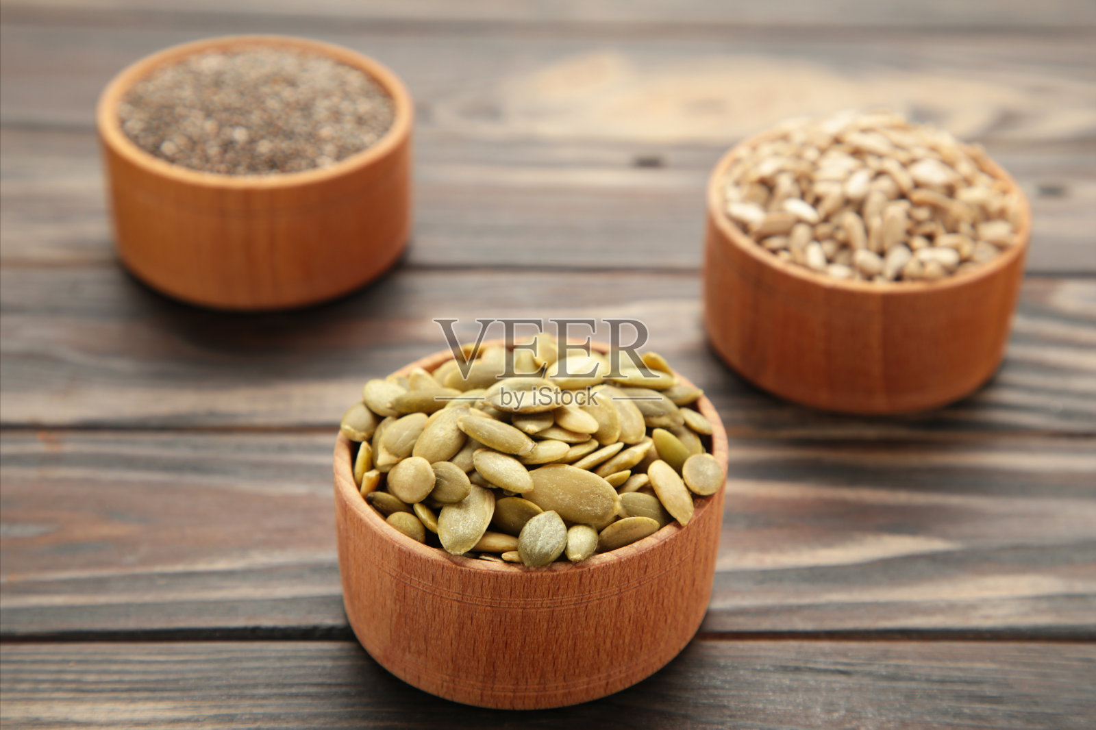 南瓜籽，奇亚，葵花籽在碗里，棕色的背景照片摄影图片