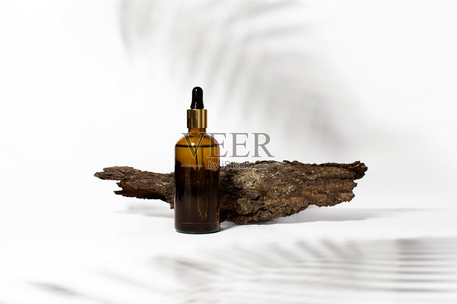 血清，油，酸，洗液在棕色滴玻璃和树皮在白色背景与热带树叶阴影，复制空间。水疗产品。有机、天然化妆品。美容、护肤概念。照片摄影图片