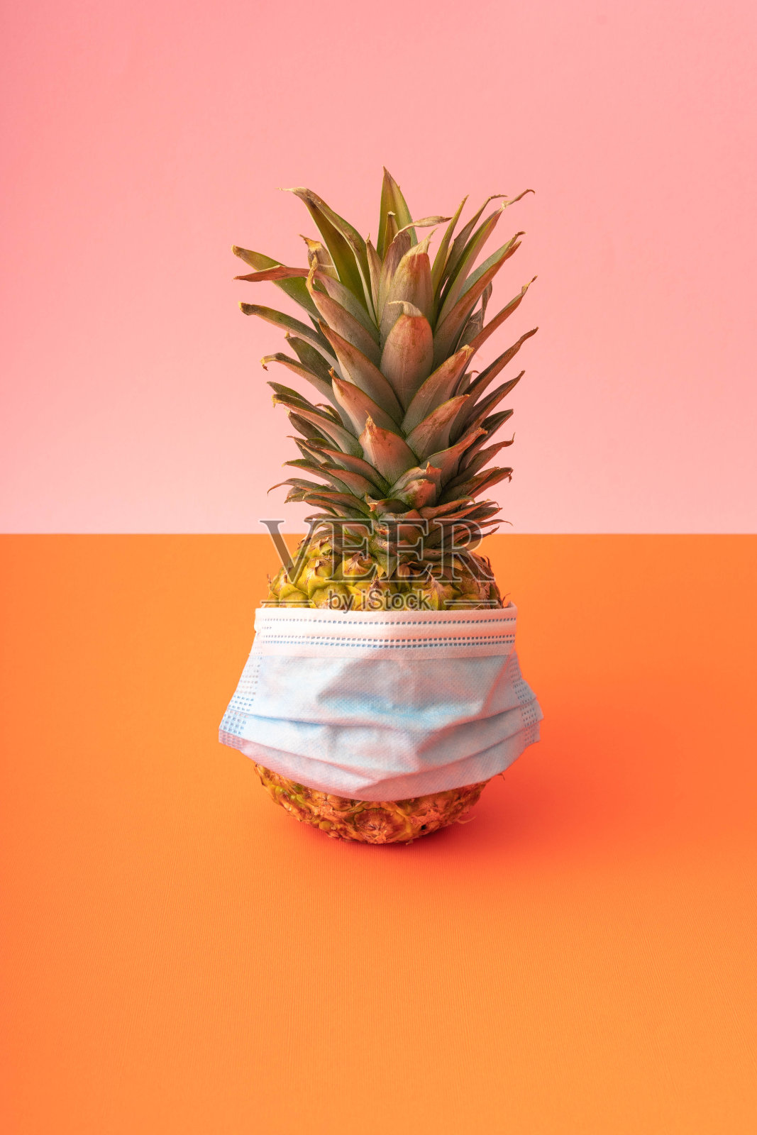 菠萝配面膜。COVID-19概念。冠状病毒感染。流行病的预防照片摄影图片