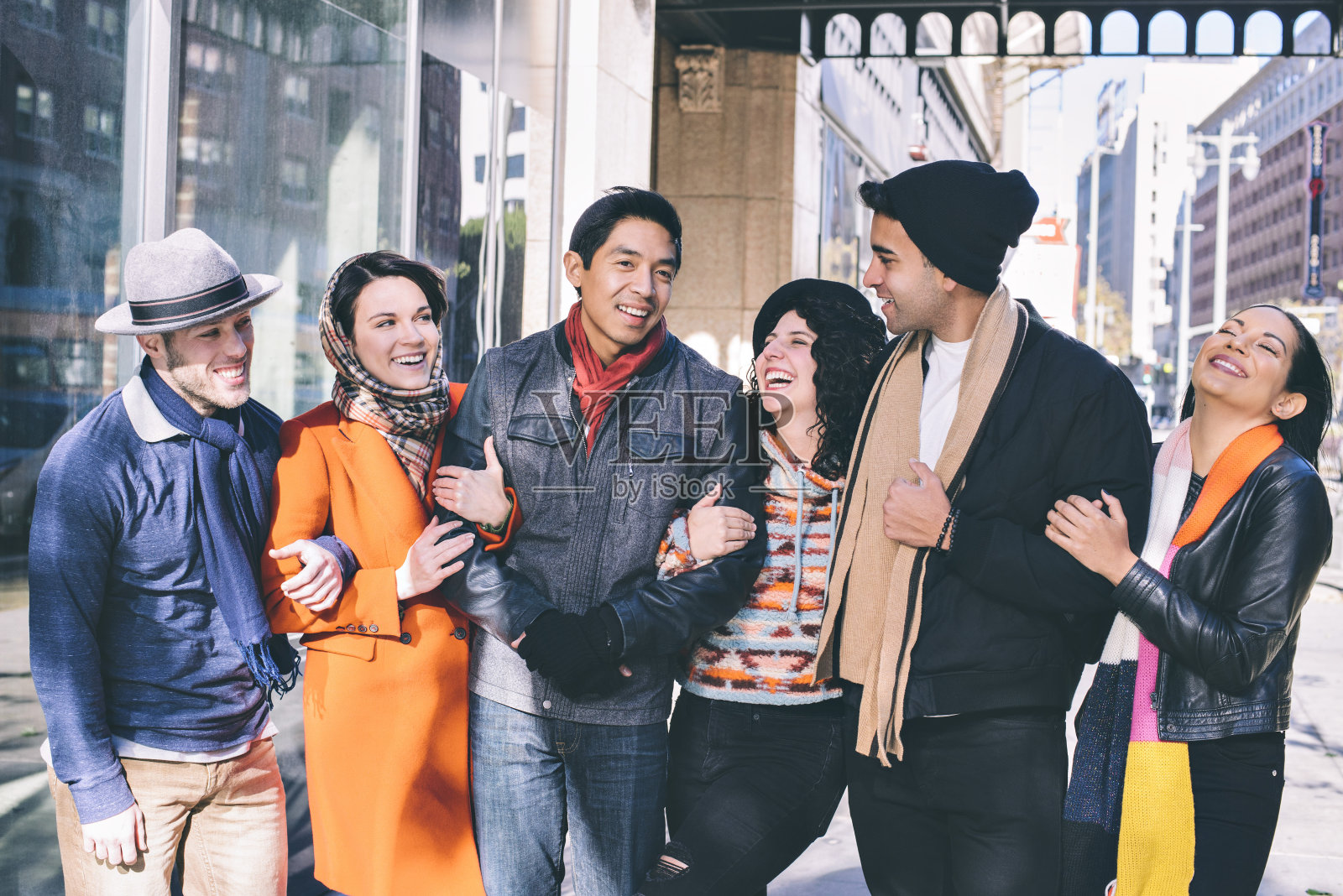 一群年轻的朋友在冬天的城市里散步-快乐-封闭-寒冷-城市照片摄影图片