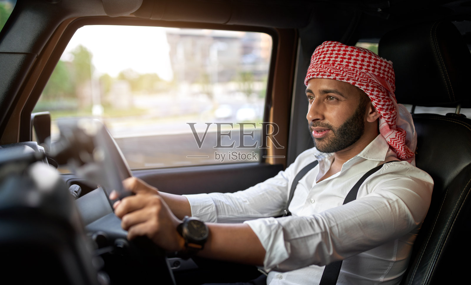 戴着传统头巾的阿拉伯商人在开车照片摄影图片