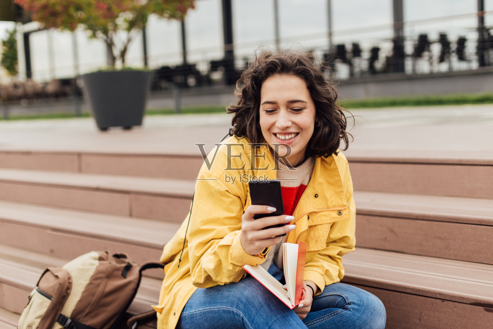 美丽的学生在户外学习和使用她的智能手机照片摄影图片