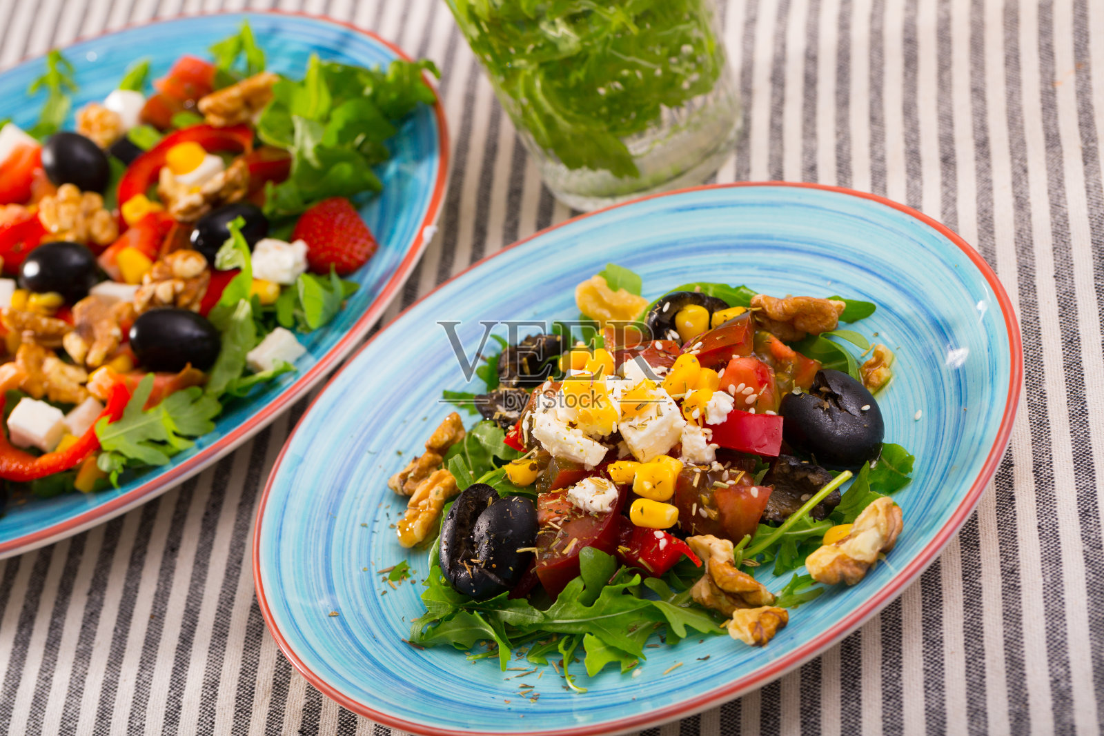 有芝麻菜、橄榄、菲达奶酪、玉米和核桃的沙拉是一道美味的菜肴照片摄影图片