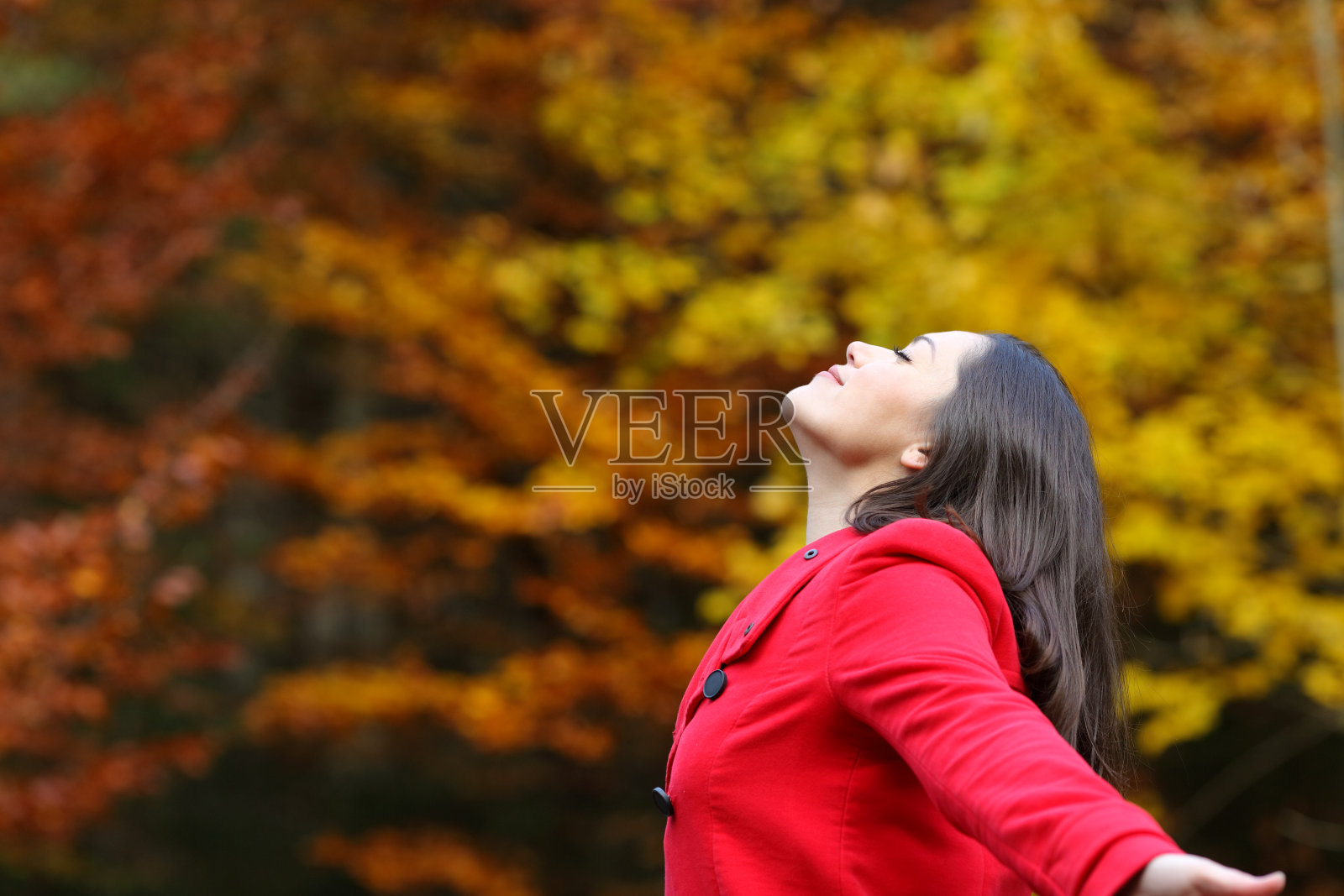 清爽的女人在红色的秋天呼吸新鲜的空气照片摄影图片