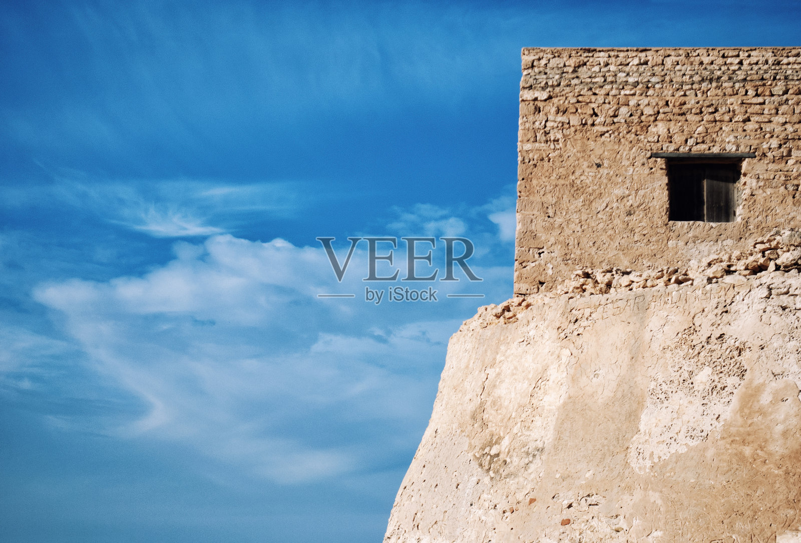 蓝色天空映衬着古老的石头建筑。照片摄影图片