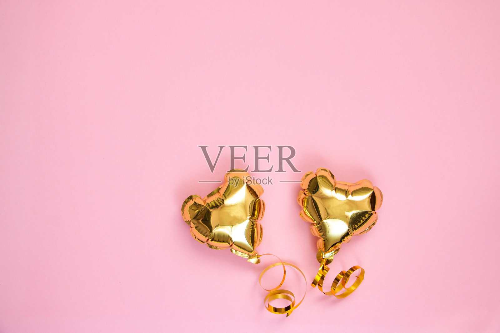 粉红色背景上的心形金色气球。情人节的概念。为文本复制空间。照片摄影图片