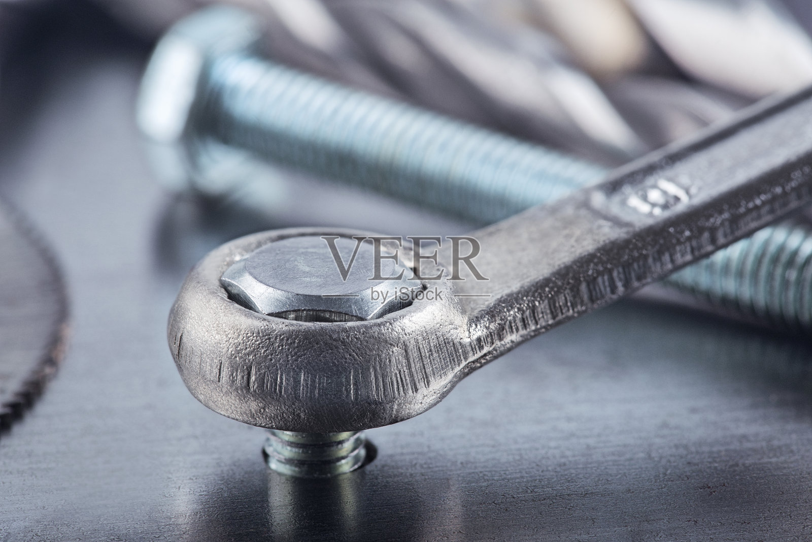 用扳手紧固钢坯中的螺栓。扳手、螺栓、螺钉和螺母。照片摄影图片