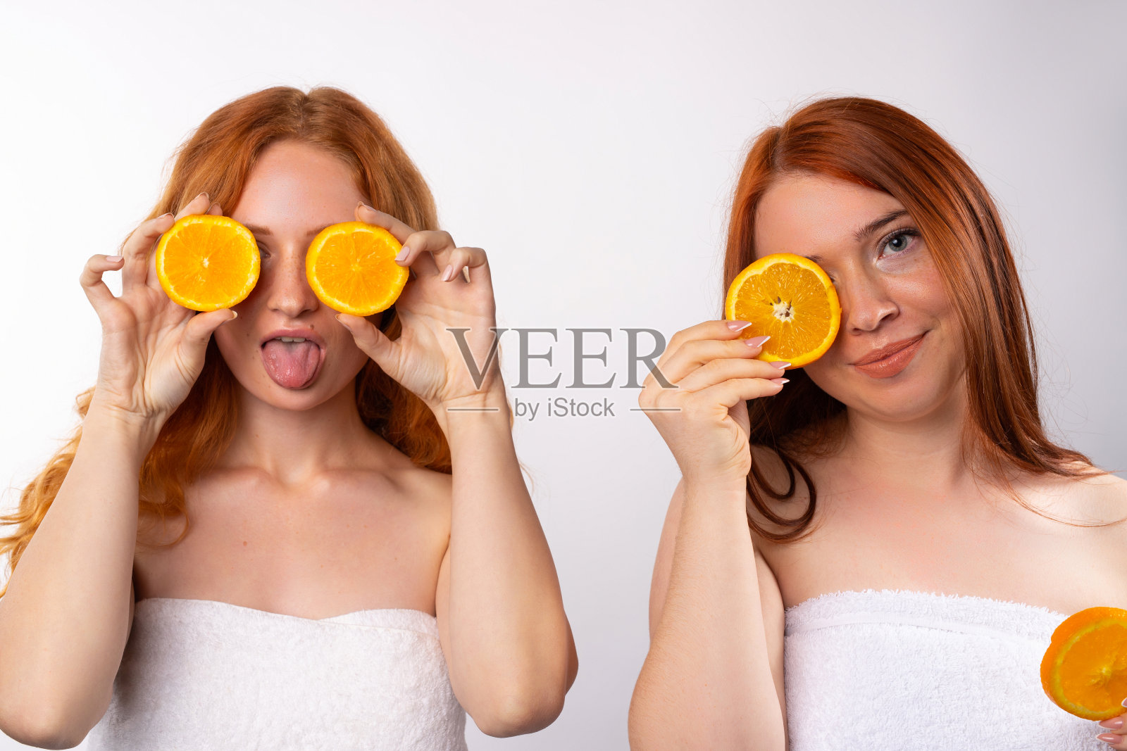 红发女孩喜欢吃橘子片。白色背景上的照片。照片摄影图片