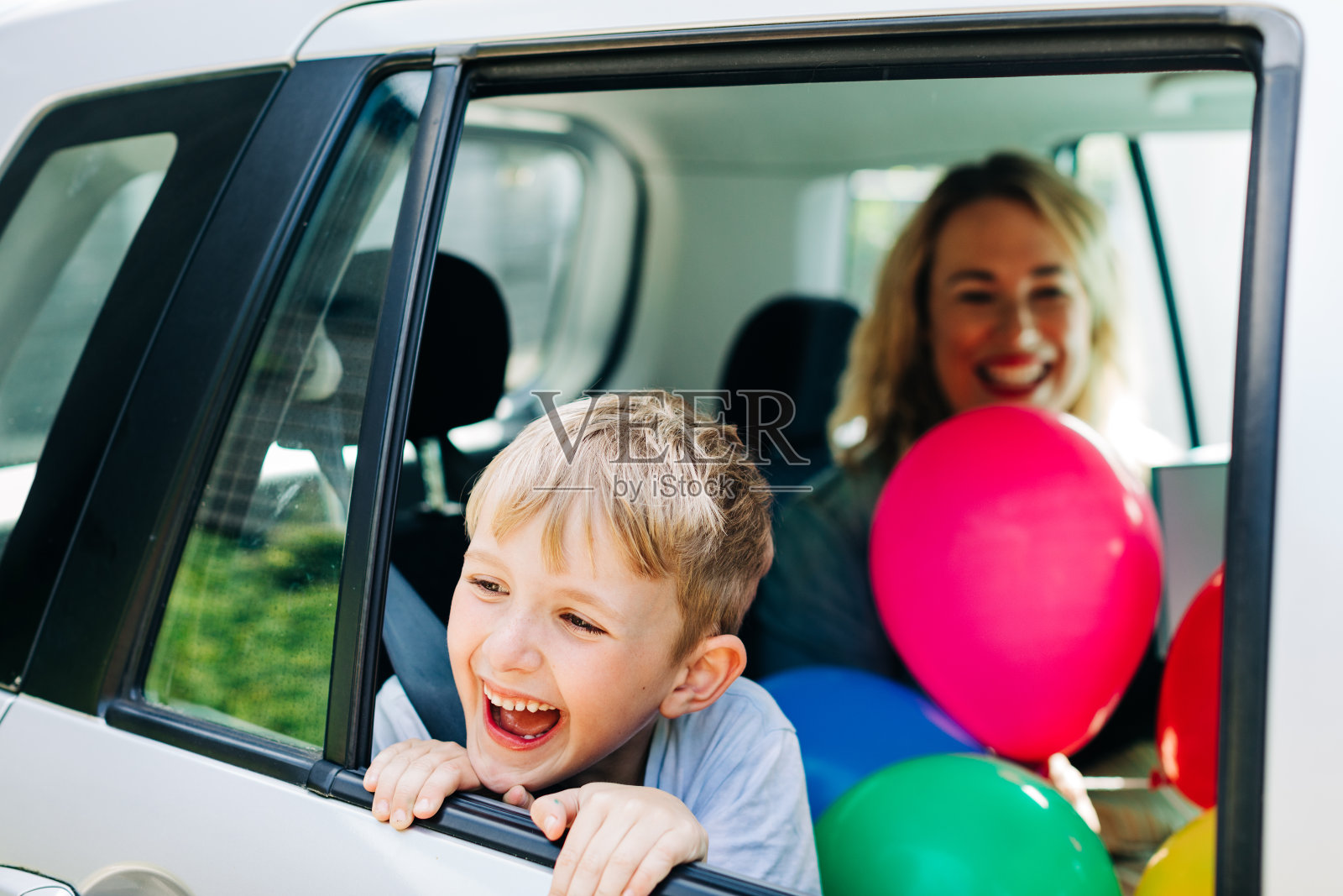 女人和男孩坐在车里大笑照片摄影图片
