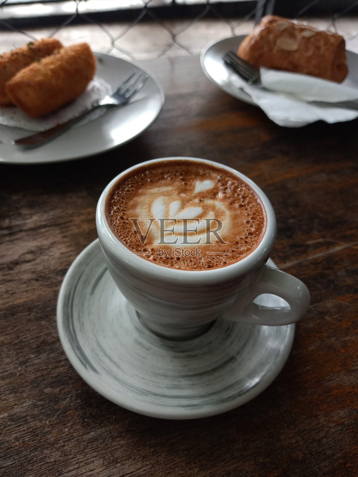 一杯短笛拿铁咖啡和零食照片摄影图片