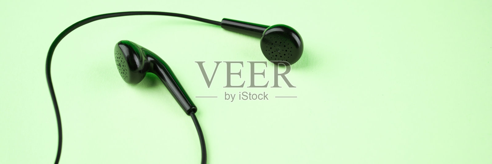 黑色耳机在绿色背景和拷贝空间。以上的观点。立体声音乐符号。旗帜模板照片摄影图片